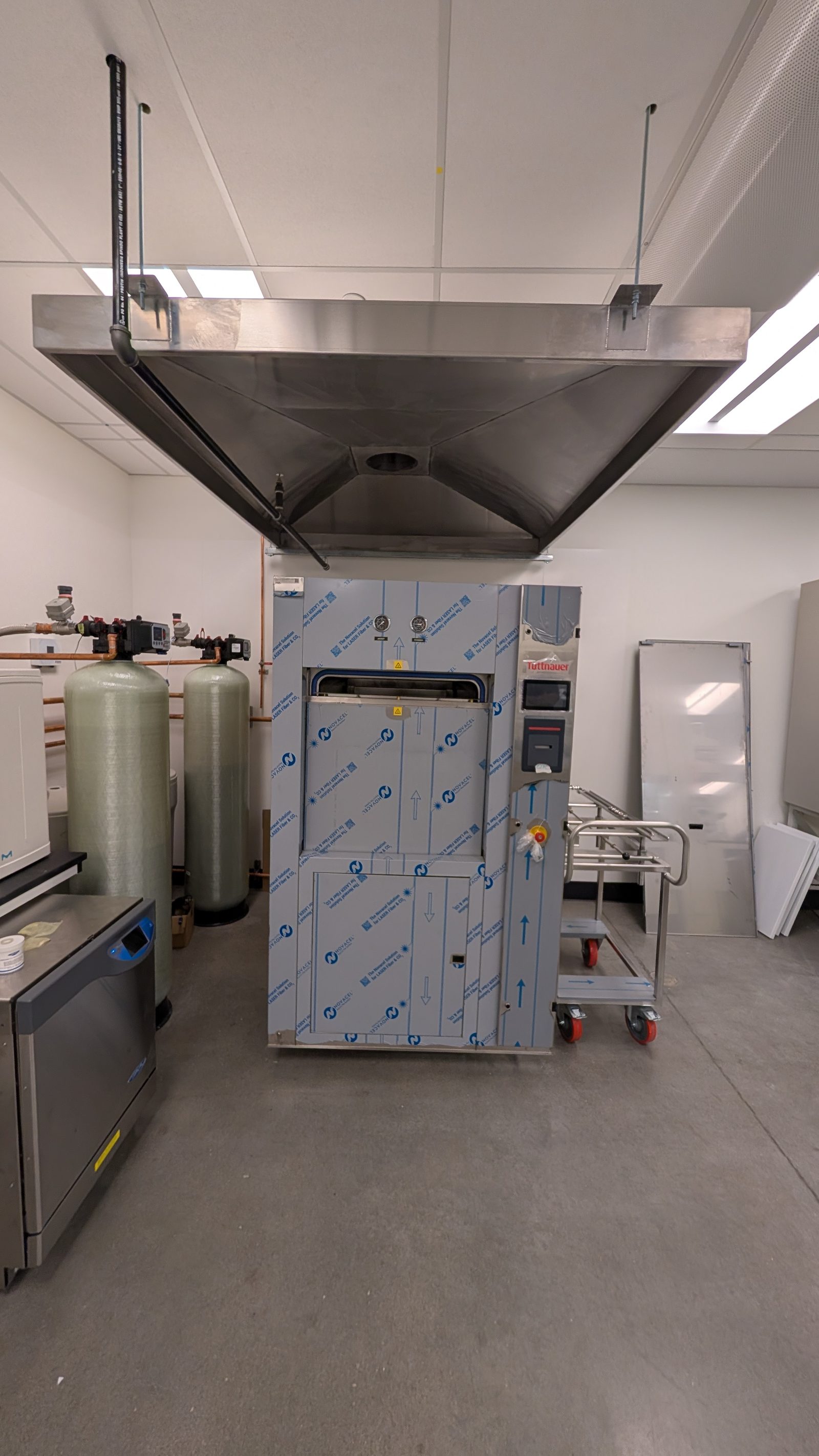 Installed Tuttnauer 66C autoclave with RO water system, exhaust hood, and loading cart at UCVM